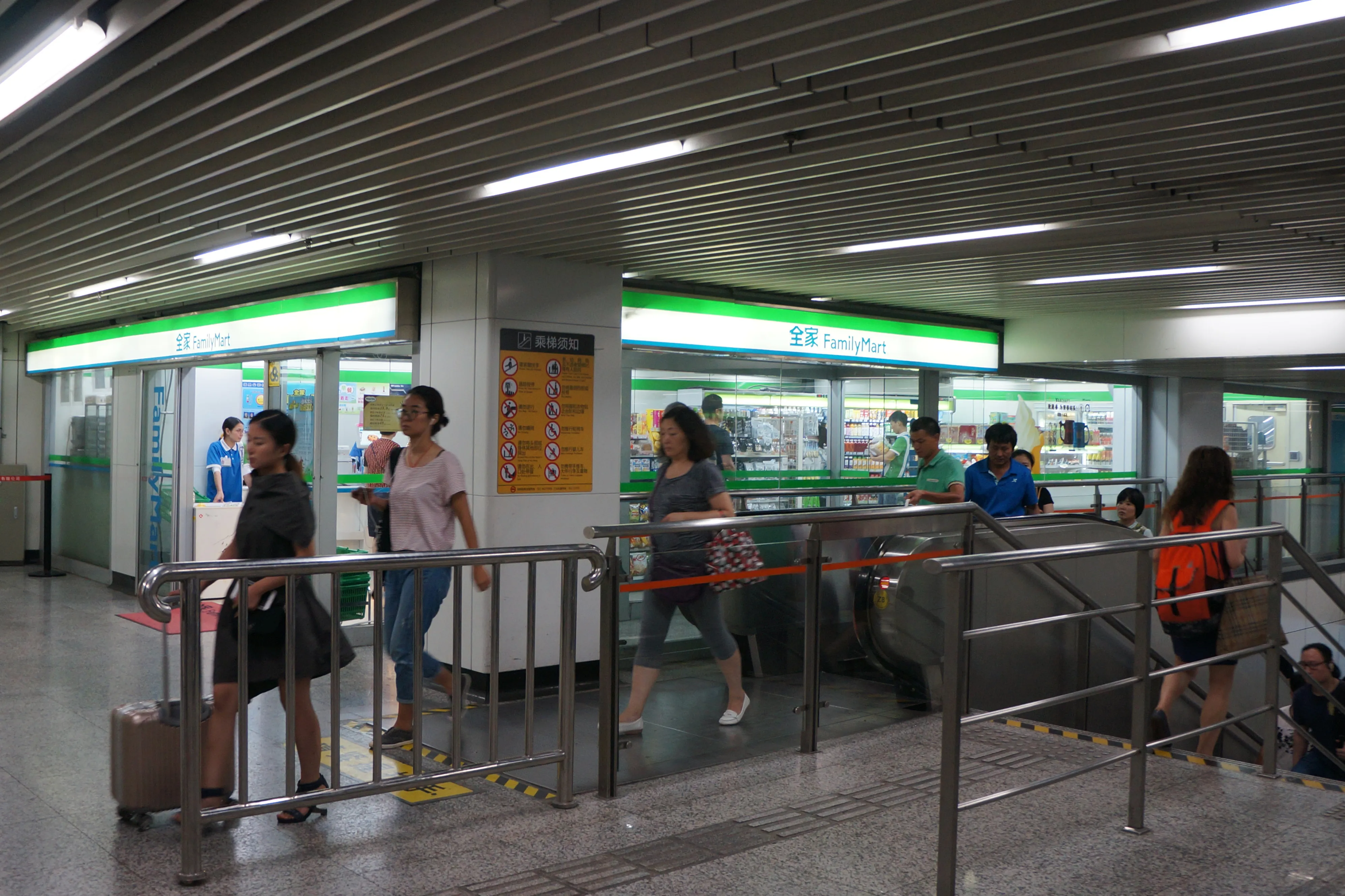 A FamilyMart convenience store inside a Shanghai metro station, with commuters walking past