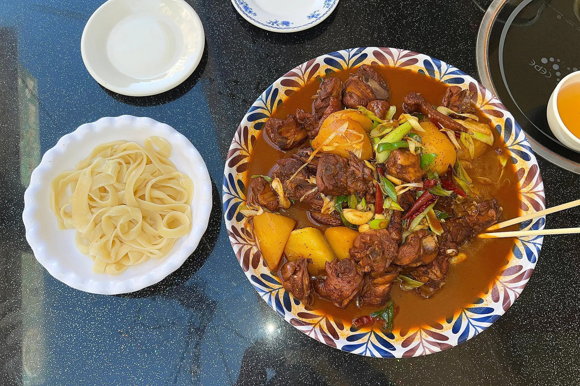 新疆の大盤鶏（大盘鸡） — 濃厚で辛いソースの鶏肉とじゃがいも — 幅広の手延べ麺を添えて